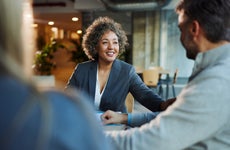 Happy banker talking to her customers in the office